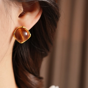 Détails des boucles d'oreilles carrées en résine caramel avec bordure dorée et œil de chat