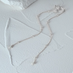Macro shot of S925 sterling silver long chain earrings with beads and opal stone