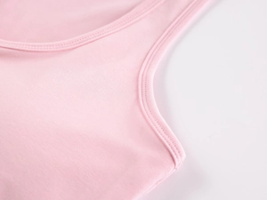Detailed macro view of pink sports tank top featuring high-density ribbed fabric and stitching