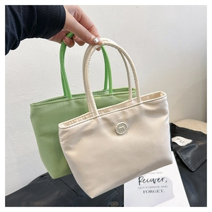 Détail de sacs seaux en nylon vert clair et beige avec logos ronds m minimalistes
