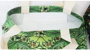 Detail view of the green William Morris canvas tote with magnetic buckle and white lining