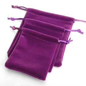 Three assorted sizes of purple velvet drawstring pouches for jewelry storage
