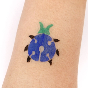 Detailed view of colorful ladybug hollow tattoo stencil applied on human arm for cosplay party