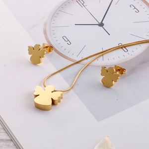 Golden titanium steel angel pendant necklace and stud earrings set on fashion magazine