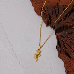 Classic golden 3D rose flower pendant necklace with fine chain on natural stone background