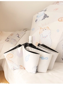 Detail of white automatic umbrella featuring cute hand-drawn cat prints and black UV coating