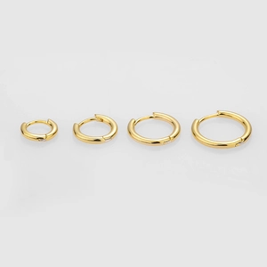 Set of four gold S925 sterling silver hoop earrings in varying sizes on grey background
