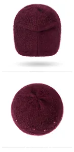Dettaglio macro del berretto in maglia bordeaux con trama pelosa e decori in perle