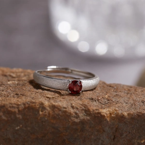 Detailed macro view of S925 silver garnet ring with brushed texture on stone base