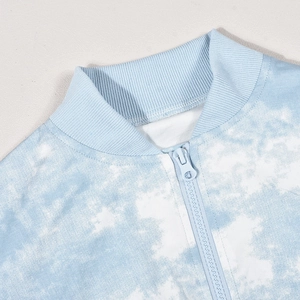 Dettaglio della felpa tie-dye blu con collo alto a costine e chiusura a cerniera
