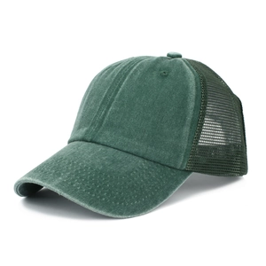 Detailed 45-degree view of dark green washed cotton trucker hat with breathable mesh