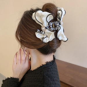 Elegant beige satin bow hair claw clip with pearls and black wavy stitching detail