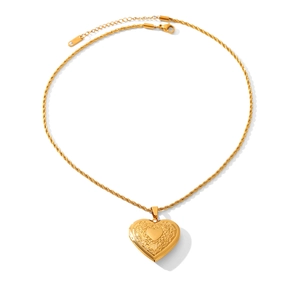Détail d'un médaillon coeur doré avec gravures vintage et sa chaîne torsadée élégante