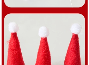 Detailed view of mini red non-woven Christmas hats with white pom poms for candy decor