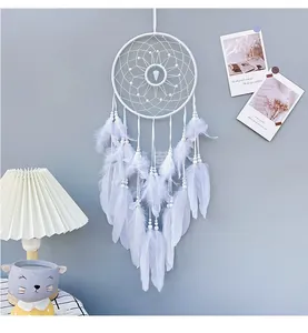 Detail of bohemian white dream catcher with woven net, beads and soft feather tassels