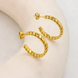 Elegant gold twisted rope C-shaped hoop earrings with a minimalist metallic texture