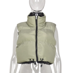 Detail of pea green puffer vest with stand collar, shiny nylon finish and drawstring hem