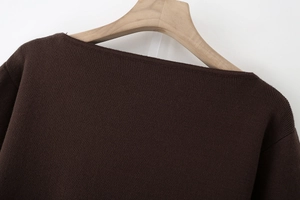 Close-up of the elegant boat neck design on a dark brown fine-knit sweater with sash