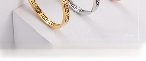 Detail of gold and silver plated titanium steel bracelets with Greek fret pattern