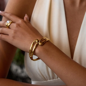 Detail of minimalist 18K gold plated double layer spring cuff and pearl ring on model