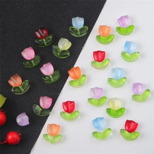 Macro shot of colorful glass tulip beads with green leaves for DIY jewelry making