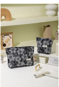 Gros plan sur le tissu jacquard floral gris d'une trousse à maquillage chic et élégante