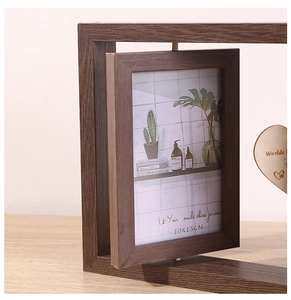 Close-up of a rotating dark walnut wood double-sided picture frame with heart pendant