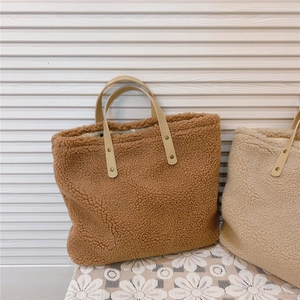 Macro detail of brown faux shearling tote bag fabric and soft leather handle
