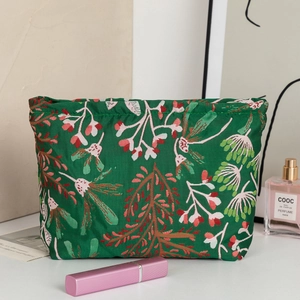 Gros plan d'une trousse de maquillage verte à motifs floraux avec des finitions de qualité