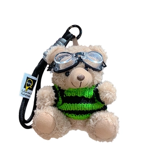 Plush pilot teddy bear keychain with green striped sweater and aviator goggles on white background
