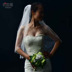Elegant long white bridal tulle veil detail with floral bouquet on black background