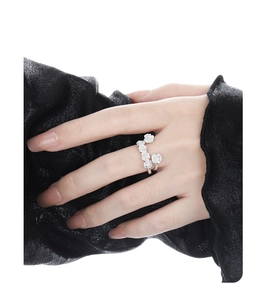 Detail of silver S925 floral wrap ring featuring intricate camellia flower design