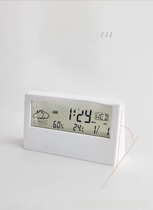Side view of white digital clock showing time, date, temperature and humidity display