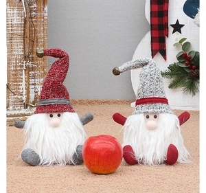 Detail of two Christmas gnomes with knitted hats and bells on a soft plush carpet