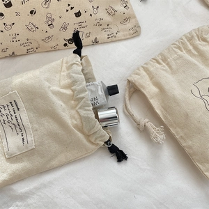 Detail of cotton linen drawstring bags with cute cat sketches and product props