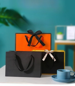 Detail of premium paper gift bags with decorative ribbon bows and sturdy rope handles