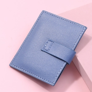 Close-up of light blue leather card holder with litchi texture and white stitching