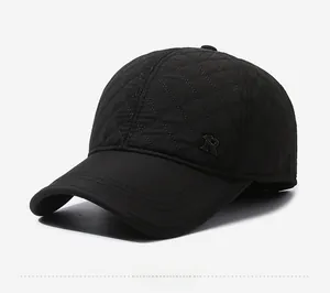 Side view of black quilted baseball cap with ear flaps and metal letter R detail