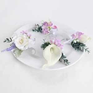 Set of four elegant artificial wedding corsages with white roses and calla lilies on a plate