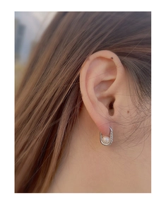 Detail of S925 silver U-shaped earring with white pearl and sparkling pavé zircons