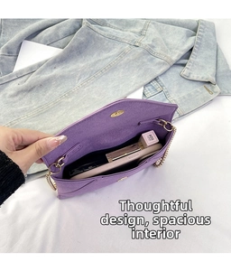 Close-up of purple matte suede crossbody bag interior with gold chain and magnetic buckle