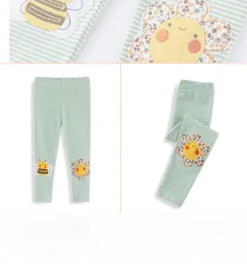 Detail of girls' cotton leggings with green and white stripes, bee and flower embroidery