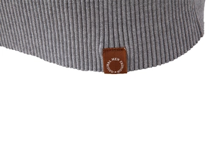 Detail der grauen Strickweste mit einem hochwertig geprägten braunen Logo-Lederetikett