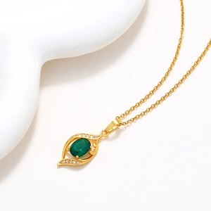 Elegant gold chain necklace featuring a vintage oval green emerald pendant with white zircons