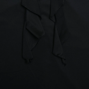 Close-up of black knit fabric featuring elegant ruffle neckline detail and texture