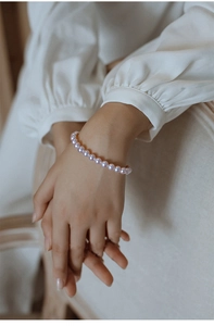 Detail of pink-purple pearl bracelet with high luster beads on model's wrist