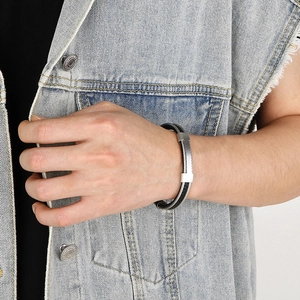Detailed view of men's black braided bracelet with matte stainless steel clasp on wrist