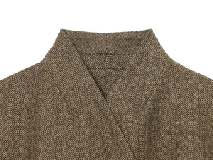 Close-up of brown herringbone blazer collar showing premium wool-like fabric texture
