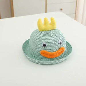 Détail du chapeau de paille vert menthe avec visage de canard et peluche jaune