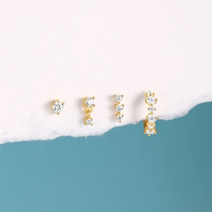 Detailed set of four gold earrings with green cubic zirconia and tassel geometric charms